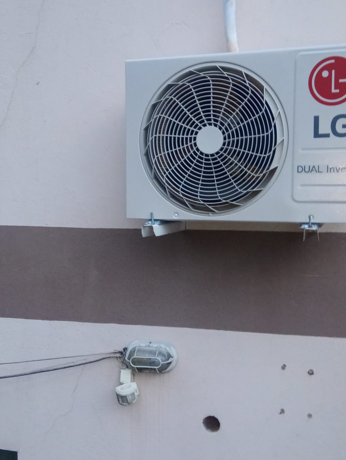 Unidade condensadora fixada em suportes na parede externa