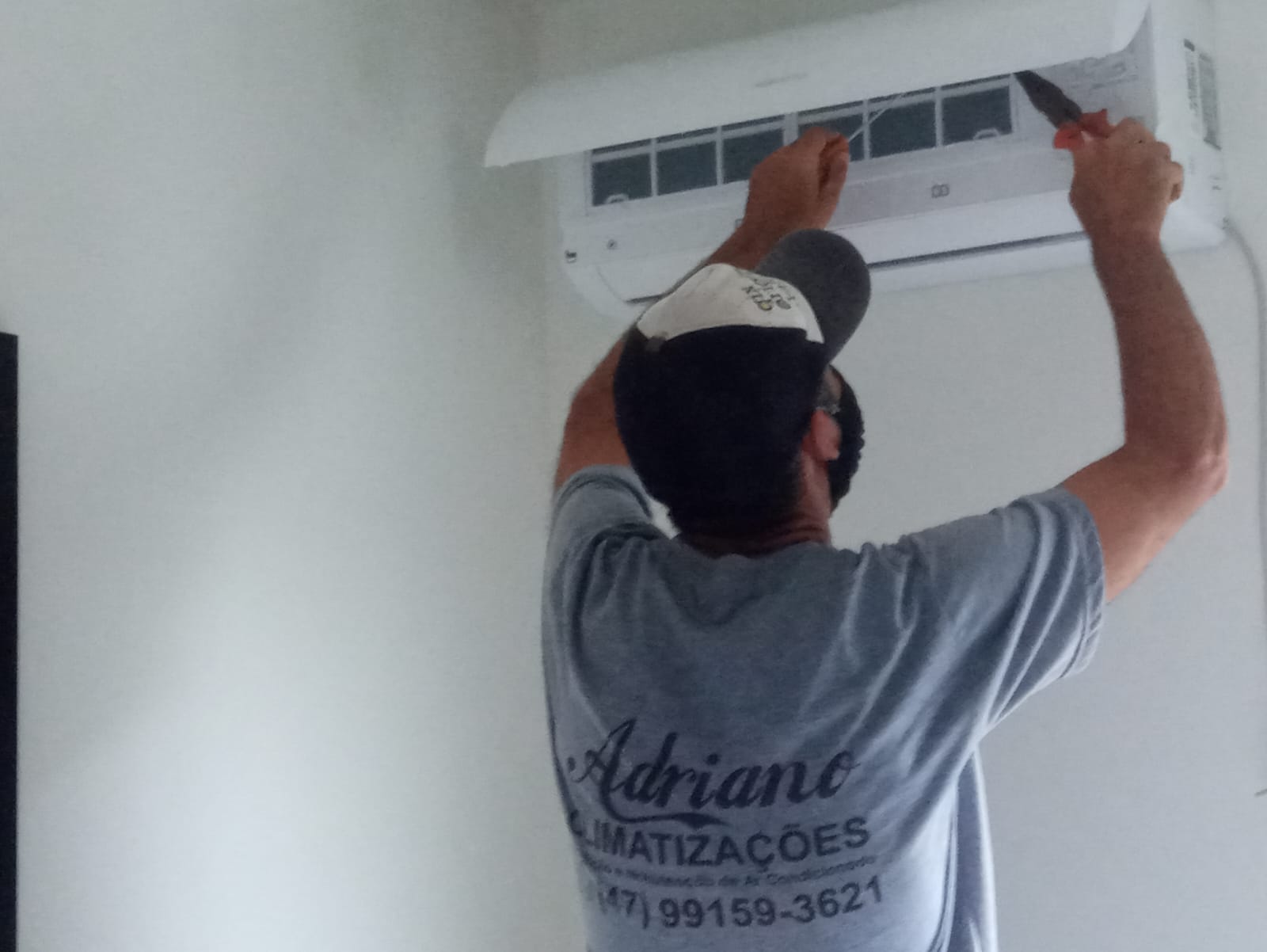 Adriano realizando serviço em unidade evaporadora de ar-condicionado